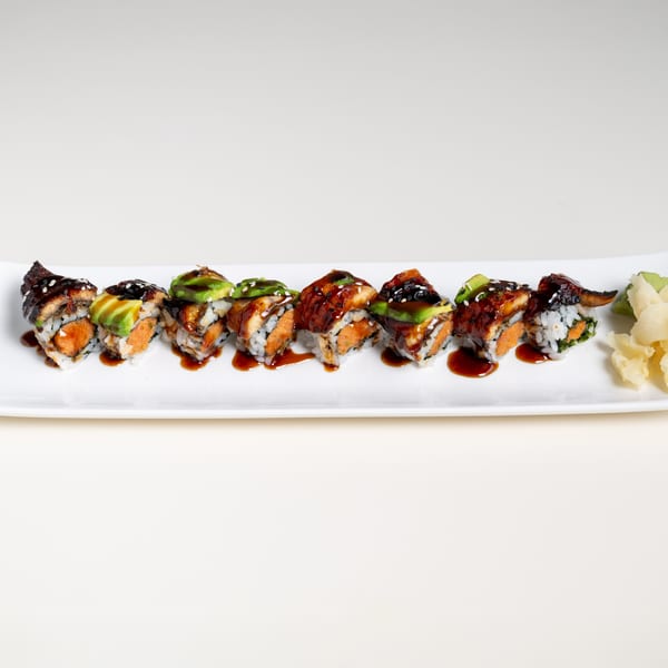 Seiko Japanese Restaurant's sushi roll with eel, avocado, and spicy salmon, drizzled with sauce.