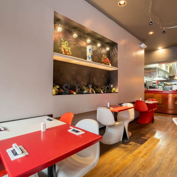 Seiko Japanese Restaurant dining area with red and white tables, modern chairs, and a decorative wall niche.